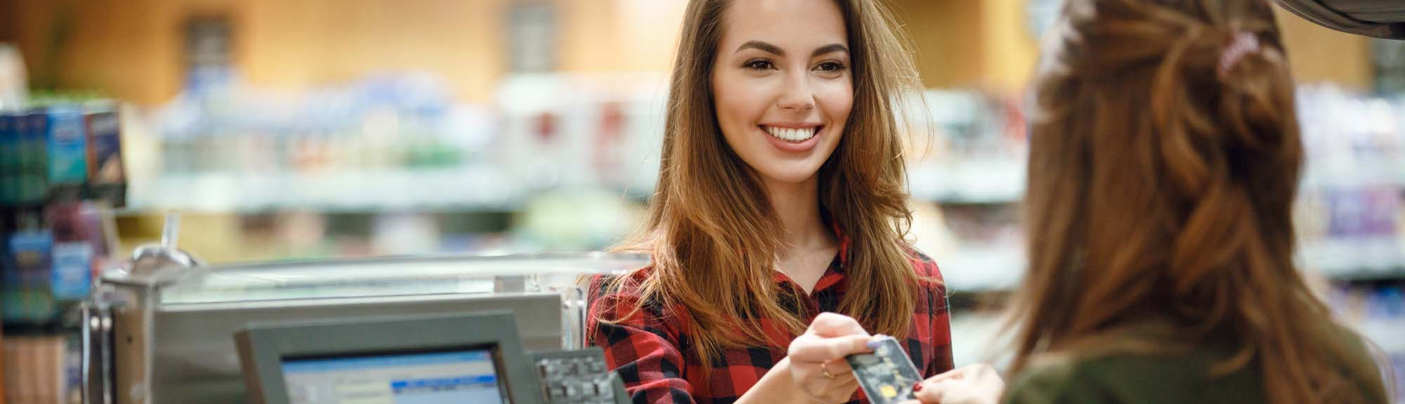 Smiling Young Lady Standing in Near Cashier